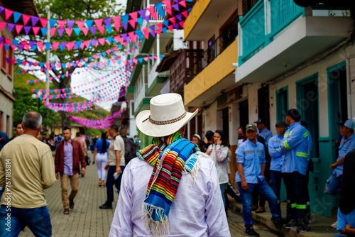 Fototapeta Naklejka Na Ścianę i Meble -  Peasant with hat and poncho walks through the streets of the town of Jerico, Colombia
