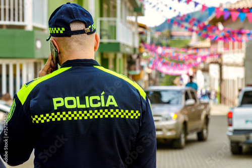 Colombian police officer seen from behind while talking on the phone photo