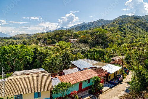 Street with colorful houses and hills in the background in Anza, Colombia photo