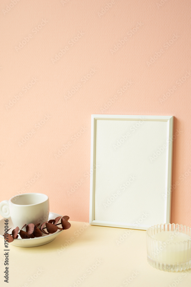 White blank picture frame with coffee cup, candle on ivory table. pink wall background
