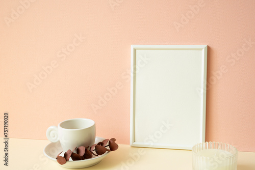 Obraz na płótnie White blank picture frame with coffee cup, candle on ivory table. pink wall background w salonie