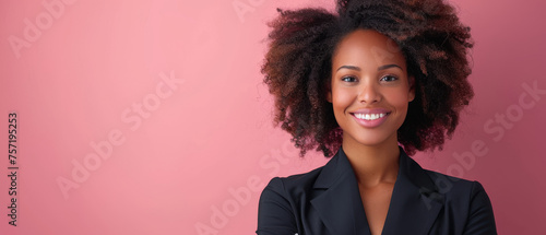 Professional young woman with afro hair and a radiant smile against pink background