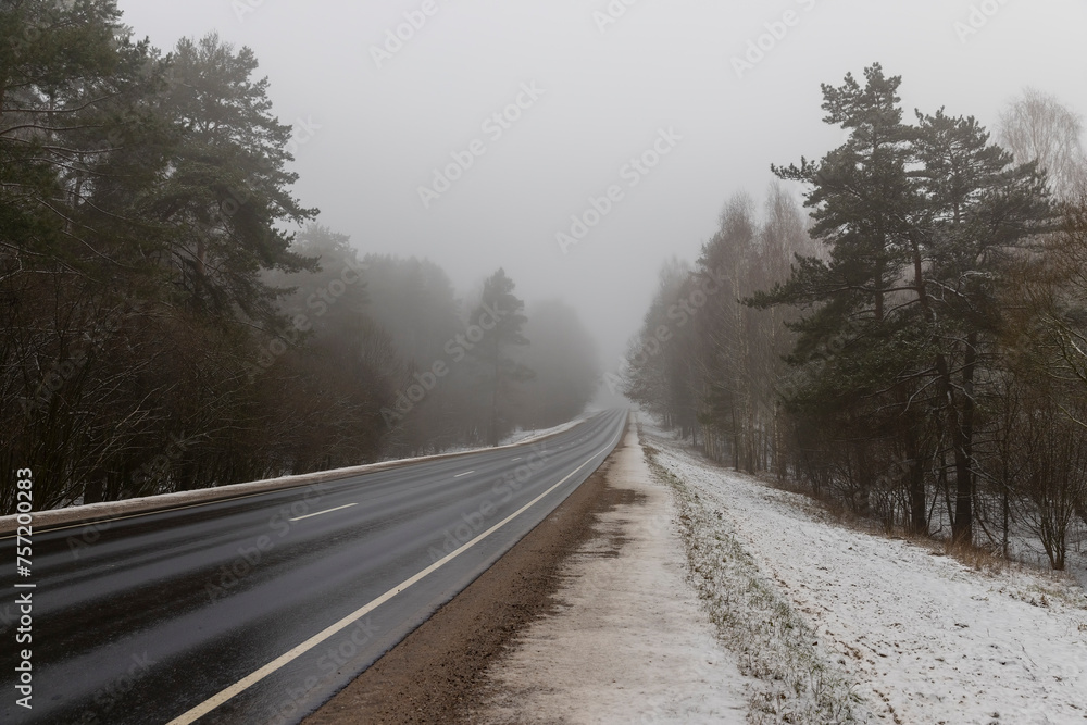 beautiful snow-covered road during fog in winter beautiful snow-covered road during fog in winter
