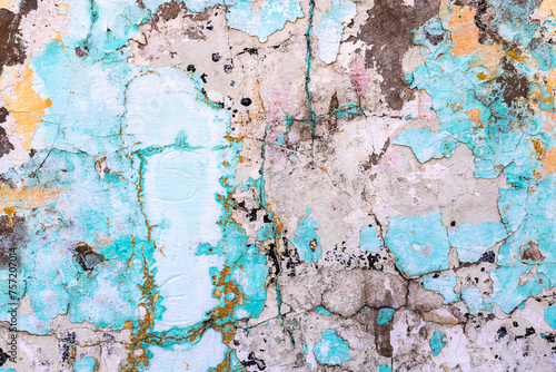 Textured background of rough and irregular wall surface in varied pastel tones, with cracks