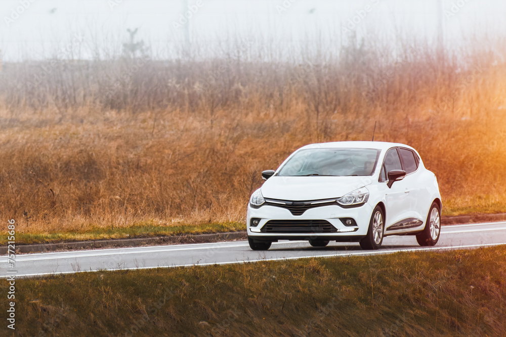 Side view of modern hatchback moving on the highway Side view of modern hatchback moving on the highway