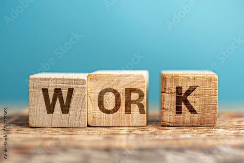Wooden blocks with the word work, light blue background.
