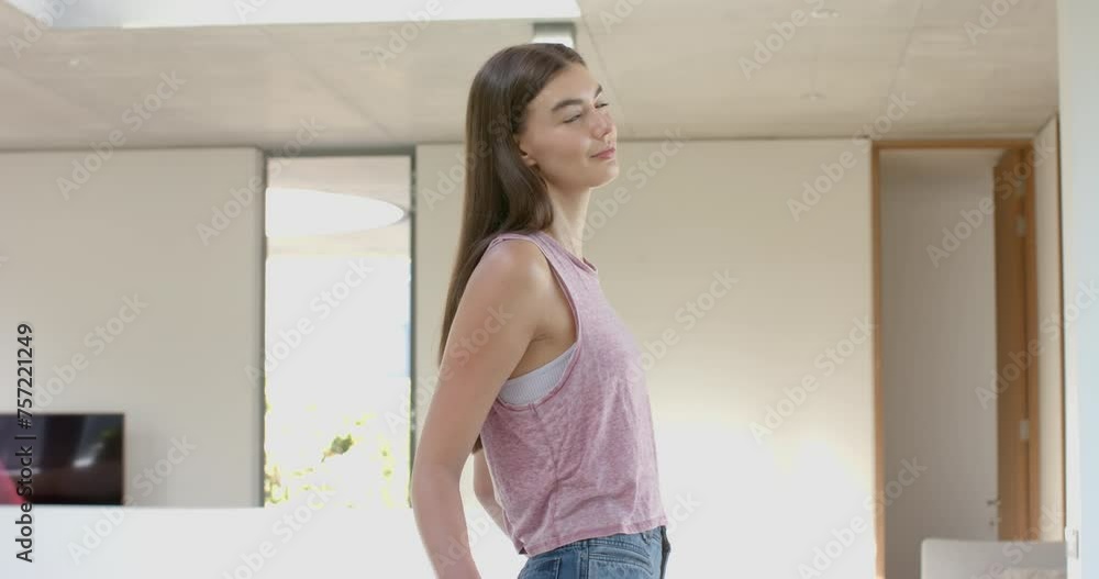Teenage Caucasian girl with long brown hair smiles in a modern home setting at home Teenage Caucasian girl with long brown hair smiles in a modern home setting at home