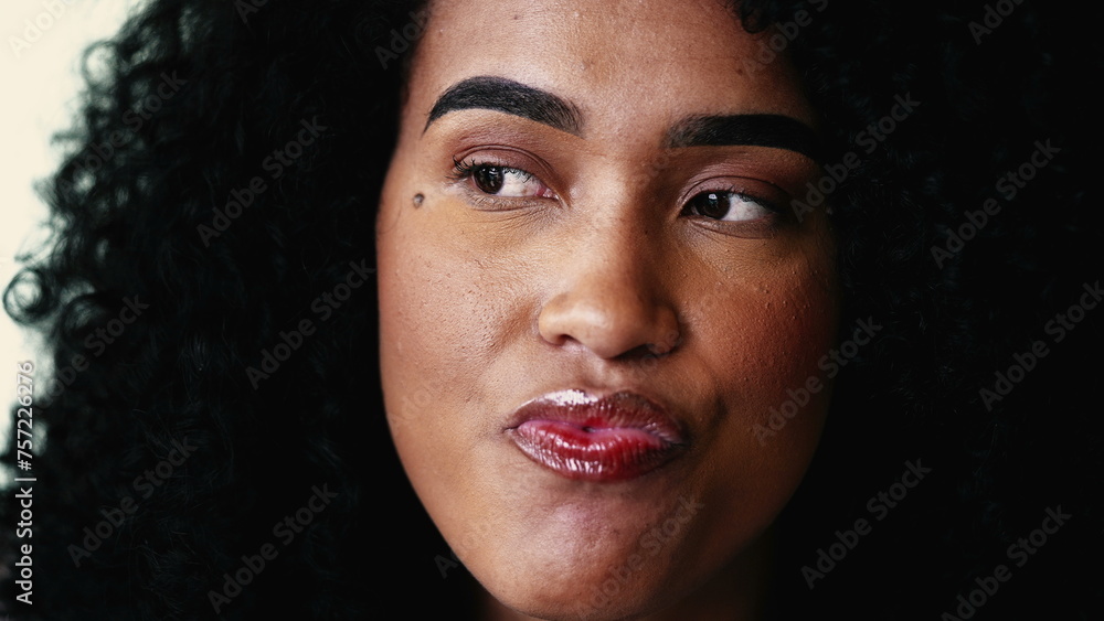 One pensive black latina woman close-up face in deep thoughtful contemplation. Person pondering decision while in dilemma gazing in the distance, lost in thought One pensive black latina woman close-up face in deep thoughtful contemplation. Person pondering decision while in dilemma gazing in the distance, lost in thought