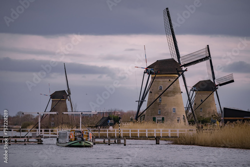 Windmills and a heavily cloudy sky in the winter, on the waterfront in Kinderdijk a national heritage in the Alblasserwaard. Medieval technological concept of water pumping with the help of wind
