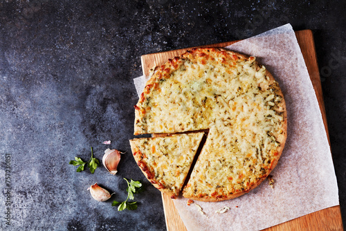 A delicious cheesy pizza served on a rustic wooden board, ready to enjoy photo