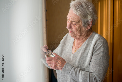 Elderly woman holding an object with a fond smile
