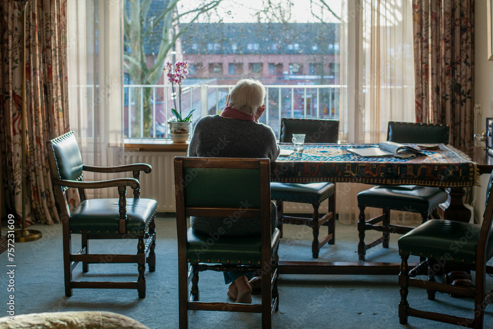 Elderly person enjoying a peaceful moment by the window as daylight streams in Elderly person enjoying a peaceful moment by the window as daylight streams in