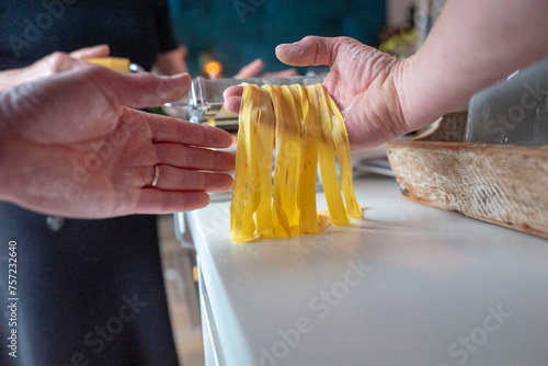 Hands preparing fresh pasta in a kitchen photo