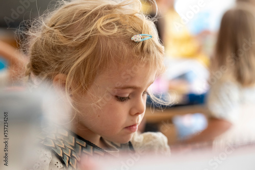 Little girl focused on a creative task at playtime. photo