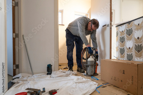 A focused handyman installing flooring in a bright room. photo