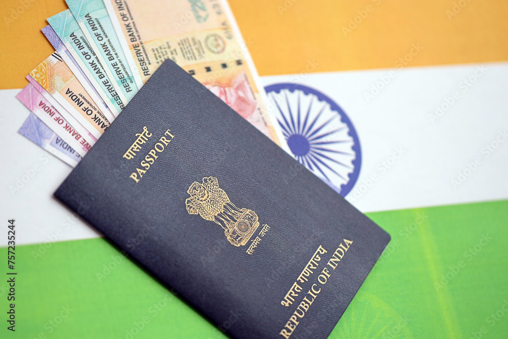Blue Indian passport and Indian rupees money bills on flag background close up. Tourism and citizenship concept Blue Indian passport and Indian rupees money bills on flag background close up. Tourism and citizenship concept
