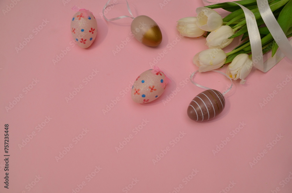 Easter, Easter egg color is bright, spring Orthodox holiday. colorful decorated eggs on a pink background. Happy Easter, white tulips. gift box tied with ribbon