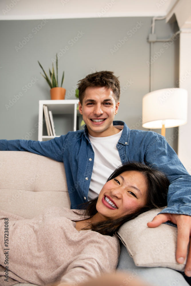 Cozy smiling wife and husband enjoying carefree free weekend time at home taking a picture. Affectionate relaxed couple sitting comfortable at their living room taking a selfie Cozy smiling wife and husband enjoying carefree free weekend time at home taking a picture. Affectionate relaxed couple sitting comfortable at their living room taking a selfie