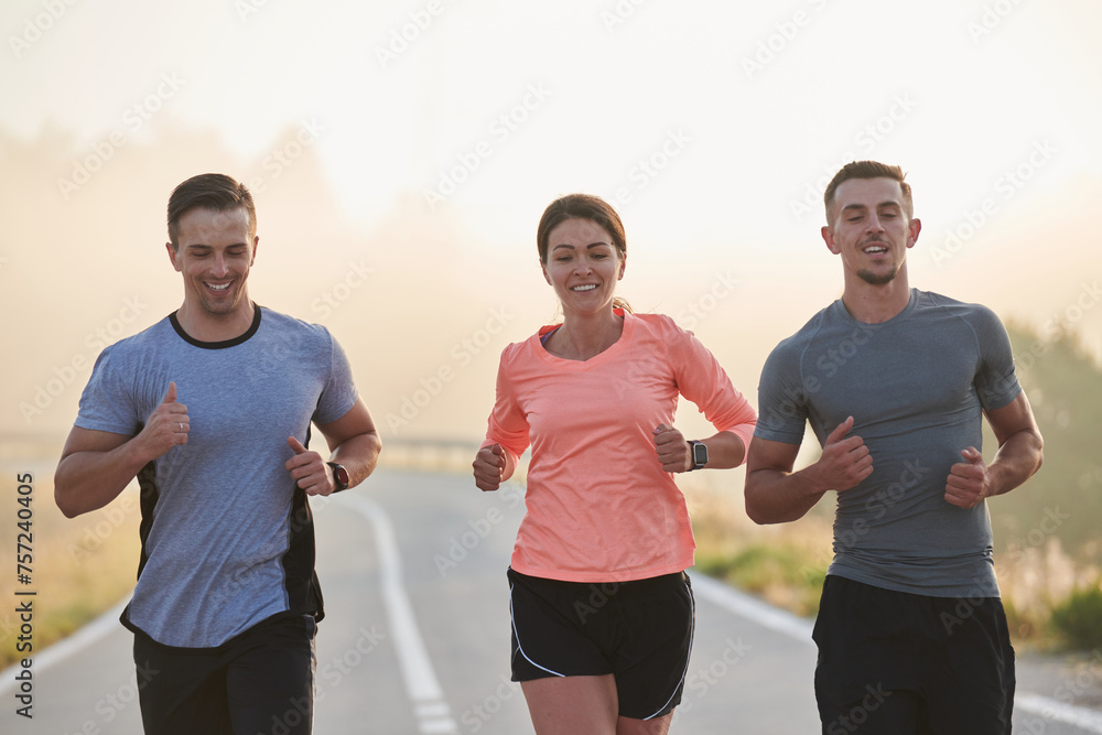 A group of friends, athletes, and joggers embrace the early morning hours as they run through the misty dawn, energized by the rising sun and surrounded by the tranquil beauty of nature A group of friends, athletes, and joggers embrace the early morning hours as they run through the misty dawn, energized by the rising sun and surrounded by the tranquil beauty of nature