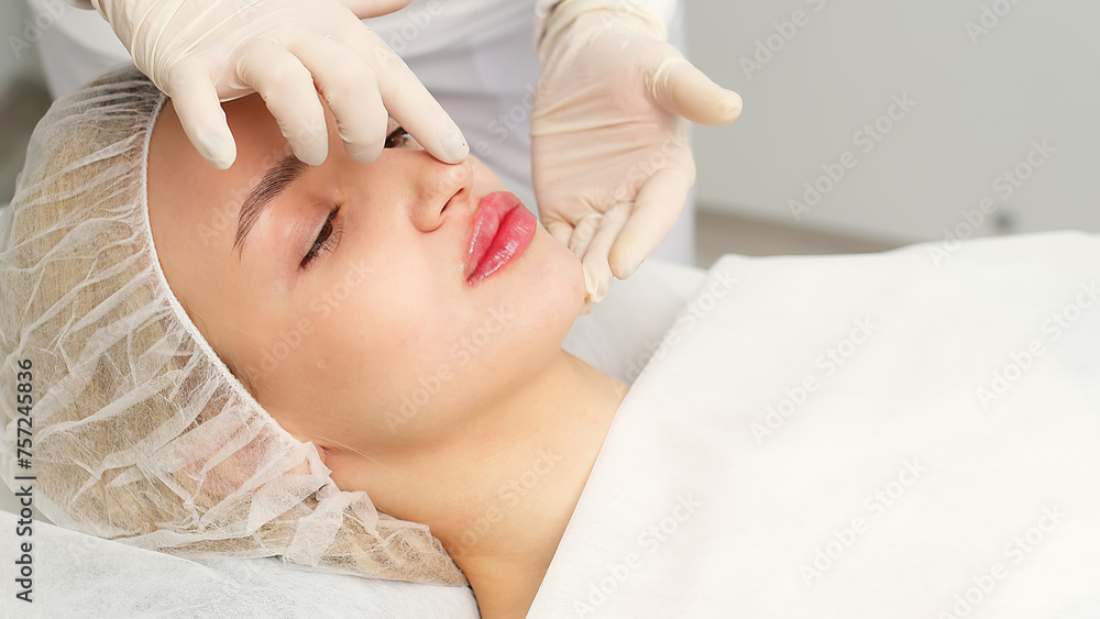 Injection procedure for lip augmentation, close-up. The cosmetologist slowly and carefully injects filler into the client’s lips. Advertising concept for facial care, youth and beauty.