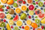 Colorful pattern of various fresh whole and sliced ripe fruits and berries