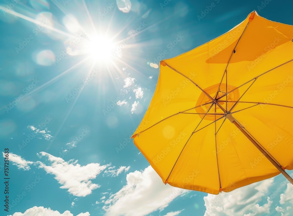 A yellow beach umbrella against the blue sky, protection from the sun.