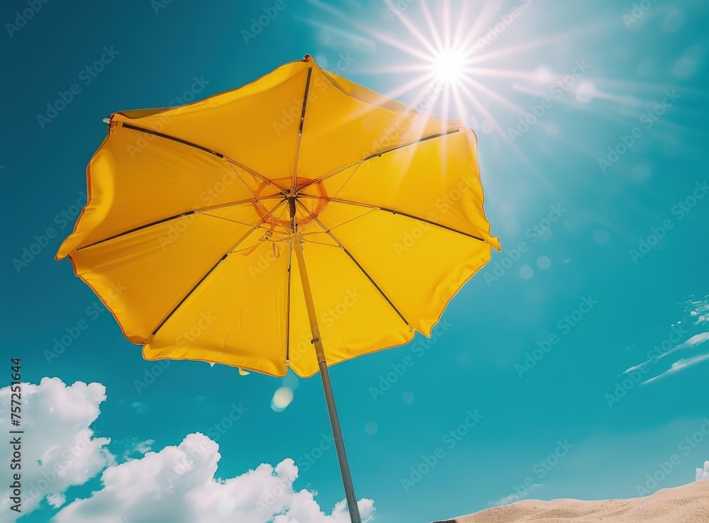 A yellow beach umbrella against the blue sky, protection from the sun.