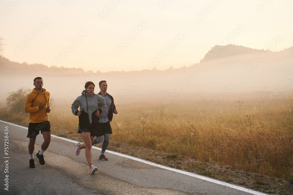A group of friends, athletes, and joggers embrace the early morning hours as they run through the misty dawn, energized by the rising sun and surrounded by the tranquil beauty of nature A group of friends, athletes, and joggers embrace the early morning hours as they run through the misty dawn, energized by the rising sun and surrounded by the tranquil beauty of nature