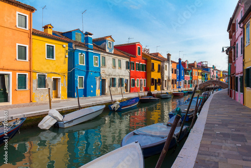 February, 2016 Burano island with colorful houses and buildings on embankment of narrow water canal with fishing boats and view of Venetian Lagoon, Province of Venice, Veneto Region, Northern Italy. B