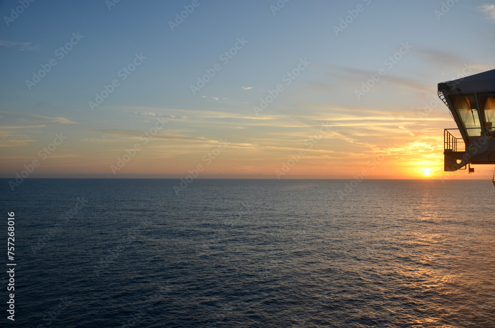 Sunset at calm sea, commander's bridge on the right,some clouds in the sky, concept for traveling, cruise traveling, planet earth