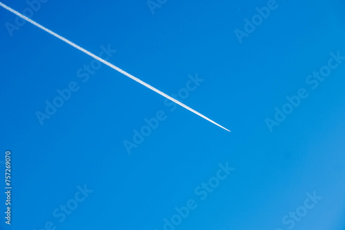 Clear Blue Sky Highlighted by Distinct Airplane Contrail.