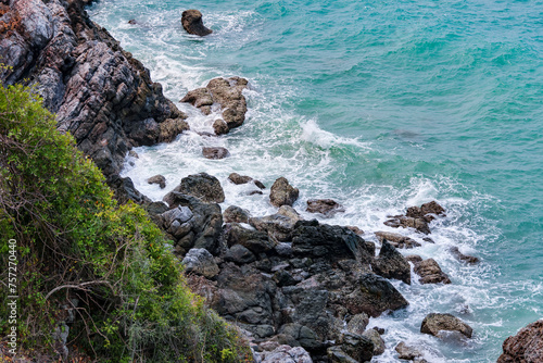 high-angle landscape of rocks by the sea The view from the mountain in the island with the cool breeze, green trees and the blue sea. The air is nice and refreshing in the summer in Thailand.