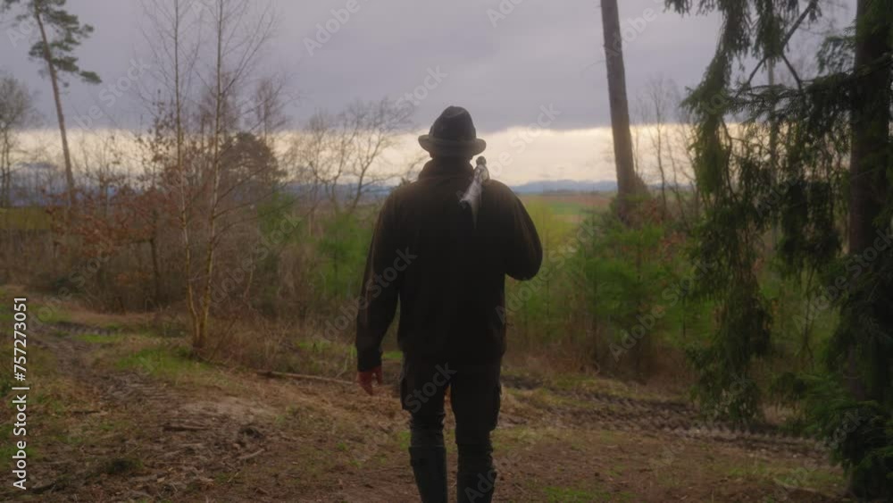 hunter walking with shotgun in the forrest at dusk hunter walking with shotgun in the forrest at dusk
