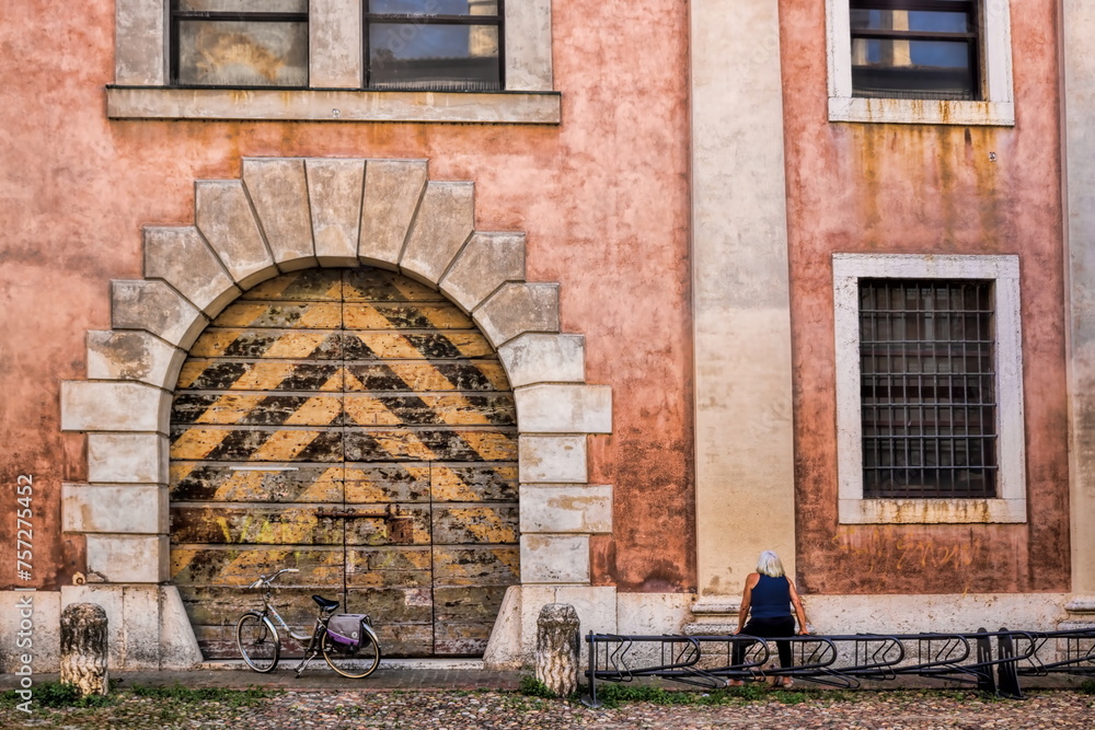 mantua, italien - verwitterte hausfassade mit altem tor