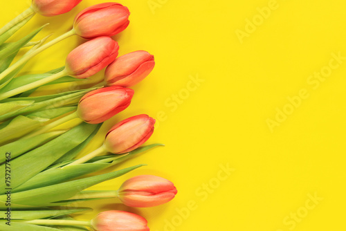 A bouquet of pink tulips lies on a yellow background, top view. Flowers for banners and cards. Bouquet for Mother's Day or other holiday. Tulips on a bright background with copy space