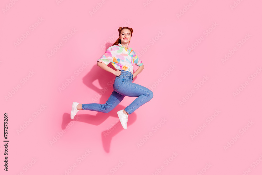 Full length size photo of freedom young attractive smiling girl touch waist jumping posing and running isolated on pink color background