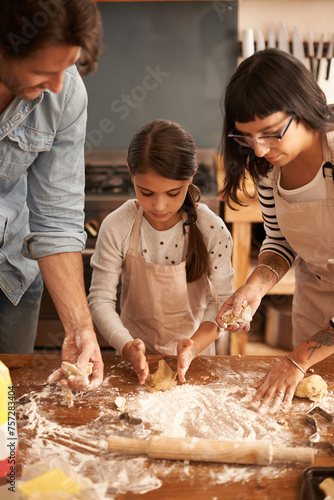 Mother, father and girl with flour for baking cookies in kitchen with dough, rolling pin and teaching with support. Family, parents and child with helping, learning and bonding with cooking for hobby