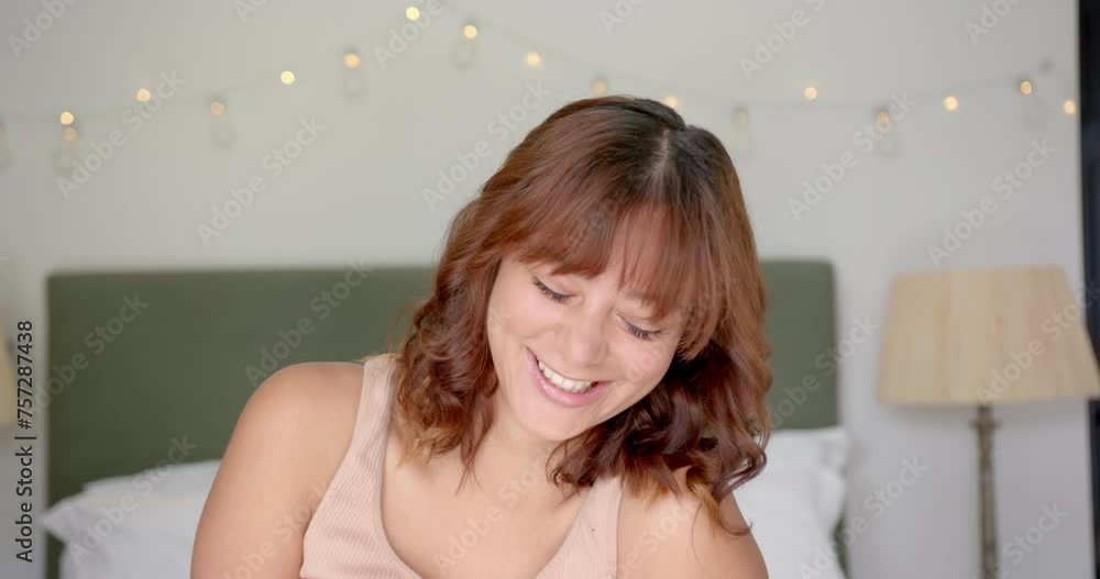 Young biracial woman with a joyful expression, indoors, in a bedroom