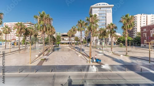 Panorama showing aerial view of the fountains and palms on the main square (Sheshi Liria) in Durres timelapse, Albania with the city hall and theater. Traffic on the street and people walking around photo