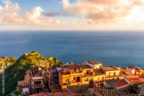 beautiful sunset scenic view of a coastline mountain town with nice roofs and streets with mountauns and hills and amazing cloudy sunset on background