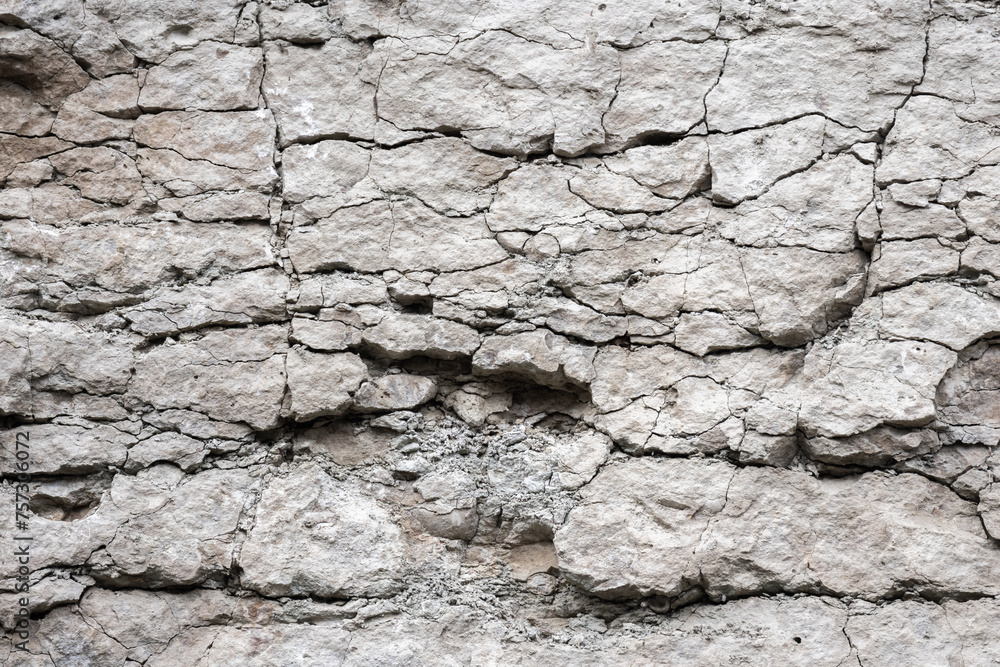 Cracked rough white rock wall, natural stone background texture