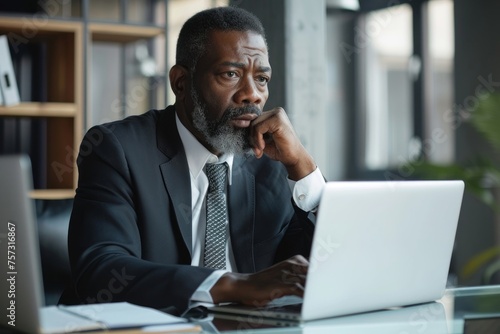 Serious mature businessman working on laptop inside office at workplace, african american boss thoughtful in business suit, successful experienced investor, Generative AI