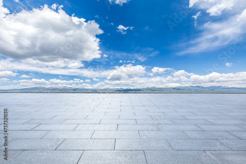 Empty square floor and mountains with sky clouds background