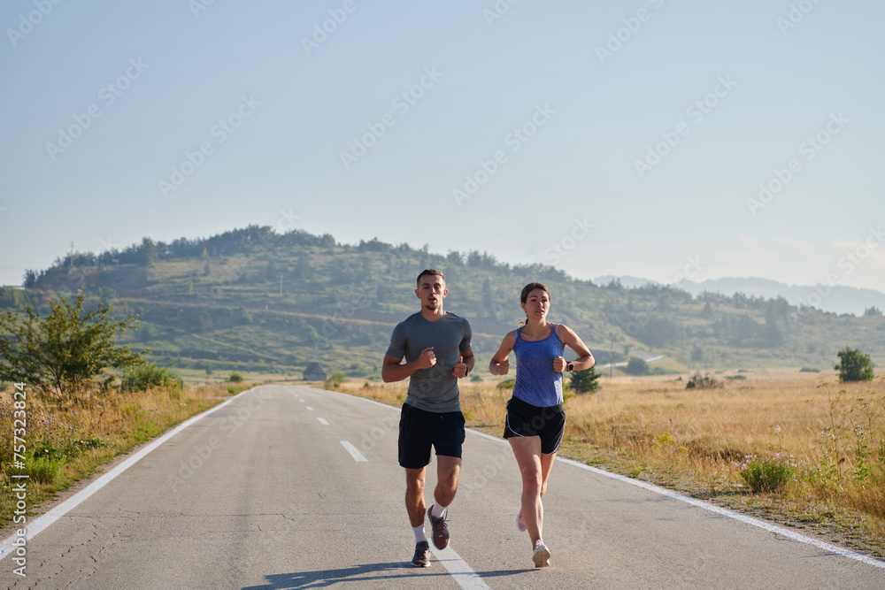 Energized by the beauty of nature, a couple powers through their morning run, their bodies and spirits invigorated. Energized by the beauty of nature, a couple powers through their morning run, their bodies and spirits invigorated.