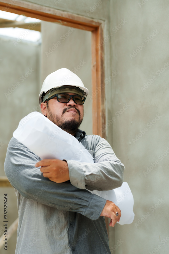 Thoughtful construction manager hugging blueprints, contemplating the next steps. Pensive engineer with plans on site, considering project details. Thoughtful construction manager hugging blueprints, contemplating the next steps. Pensive engineer with plans on site, considering project details.