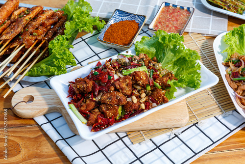 Crispy crunchy Spicy Chili Chicken cooked with bits of meat, chilies, peppercorns, peanuts, and cilantro. photo
