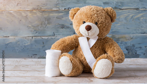 children's toy teddy bear sits with a bandaged head. Childhood trauma concept