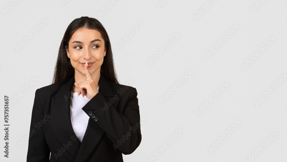 Young businesswoman with secret gesture, free space Young businesswoman with secret gesture, free space