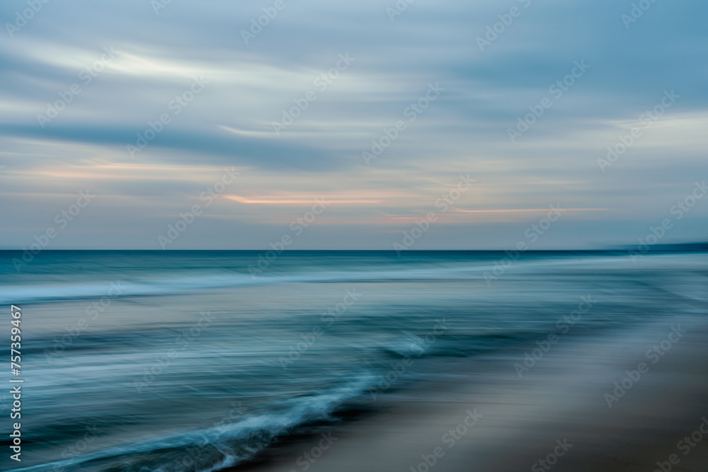 Abstract seascape background, motion blur. Sunset on the beach, waves breaking on the shore