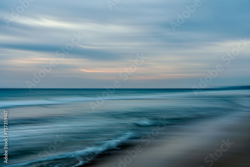 Abstract seascape background  motion blur. Sunset on the beach  waves breaking on the shore